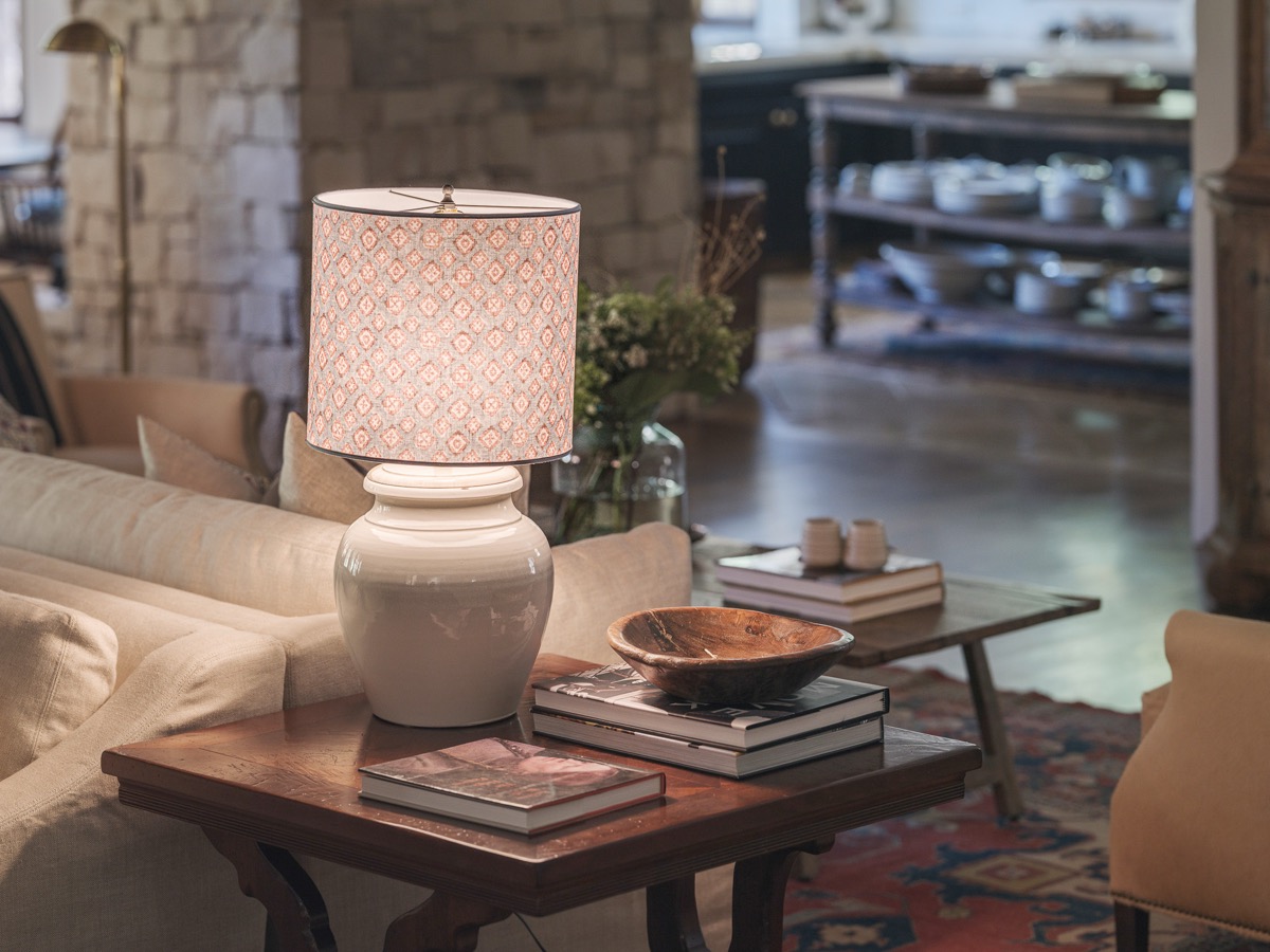 Ceramic lamp and stacked books on a wood side table, styled by Hart Habitats