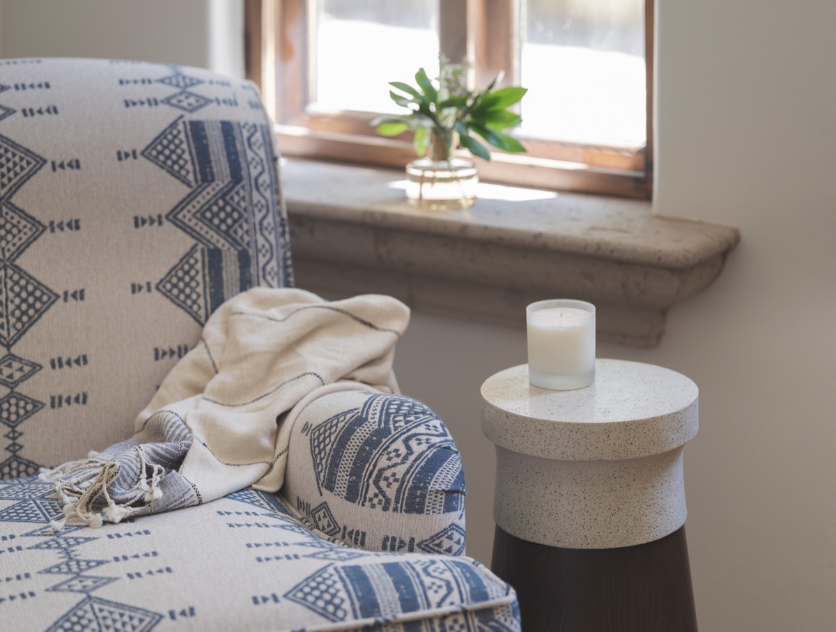 Window seat corner with a stone sill and pedestal candle table