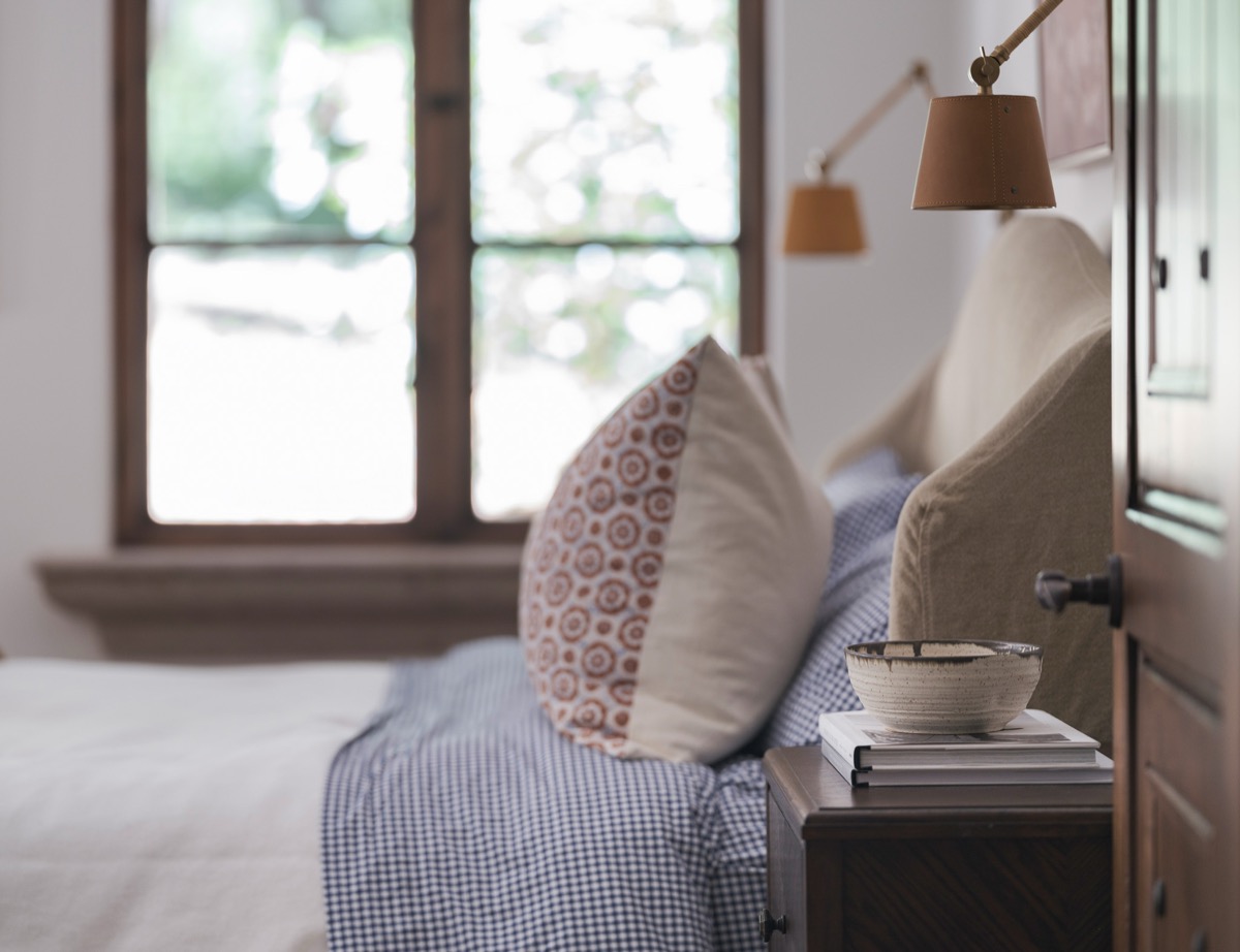 Bedroom nightstand with sconce lighting and a patterned throw pillow