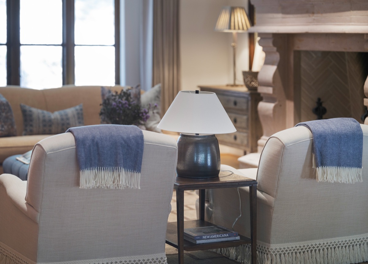 Armchairs with blue throws beside a stone fireplace