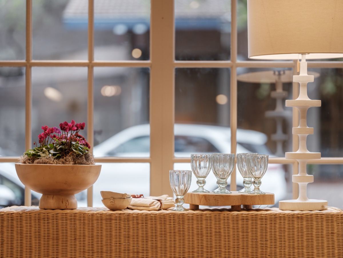 Window table styled with glassware and fresh flowers at the Hart Habitats shop