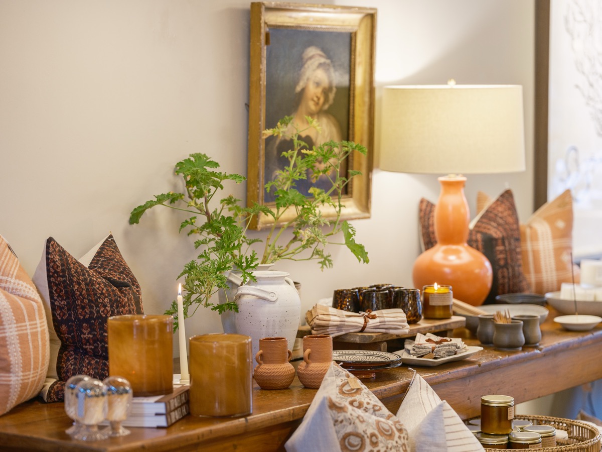 Console table with a framed painting, plants and ceramic vases