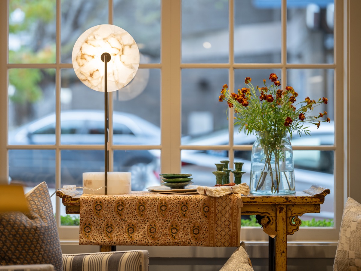 Window nook with a floor lamp and glassware at the Hart Habitats shop