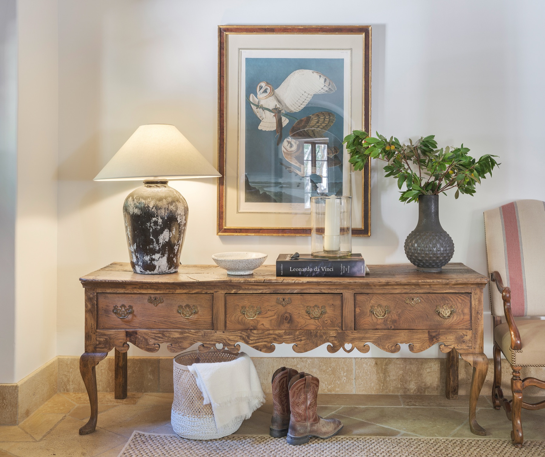 Warmly styled interior with antique console, lamp and artwork